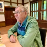 Ein weiterer Gast an der Stirnseite des Tisches